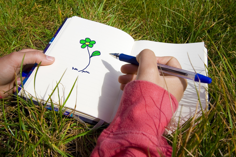 Girl Drawing Flower in Notebook Grief Support